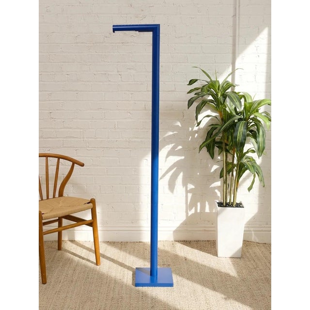 A striking vintage Italian floor lamp with a slim, architectural silhouette and saturated blue painted finish. The tall...