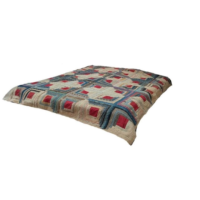 This vintage quilt features a traditional "Log Cabin" pattern, likely crafted during the late 19th or early 20th century....