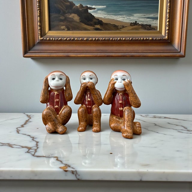 A refined and whimsical set of three vintage Chinese export porcelain monkey figurines, each representing the traditional...