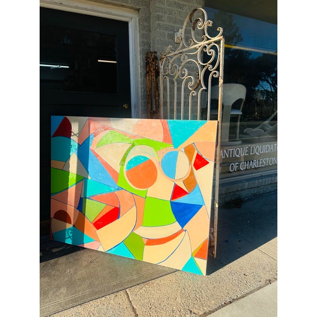 This painting is a vibrant abstract composition characterized by bold geometric shapes and vivid colors. The interplay of...