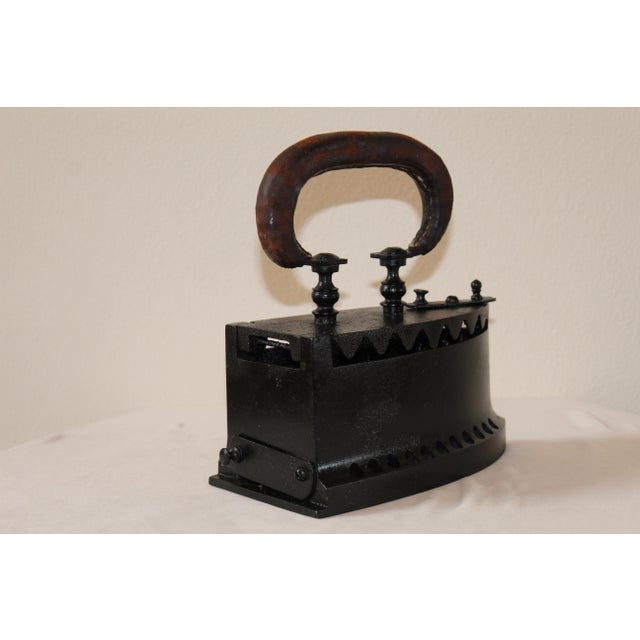 Step back in time with this early 20th-century cast iron charcoal sad iron. With its solid cast iron body and iconic...