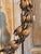 Gilt tole wreath formed as an oval garland of seed pods and buds on slender stems, gathered at the top beneath a tied...