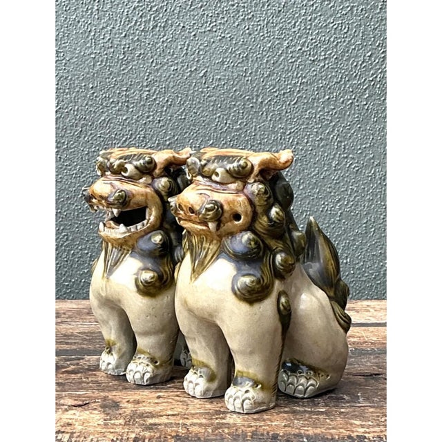 This pair of vintage ceramic Foo Dog guardian statues captures the traditional, protective character of the mythological...