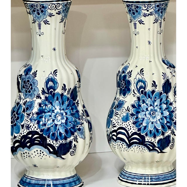 A striking pair of hand-painted Delft-style porcelain vases produced by Royal Goedewaagen, one of the Netherlands’ best-...