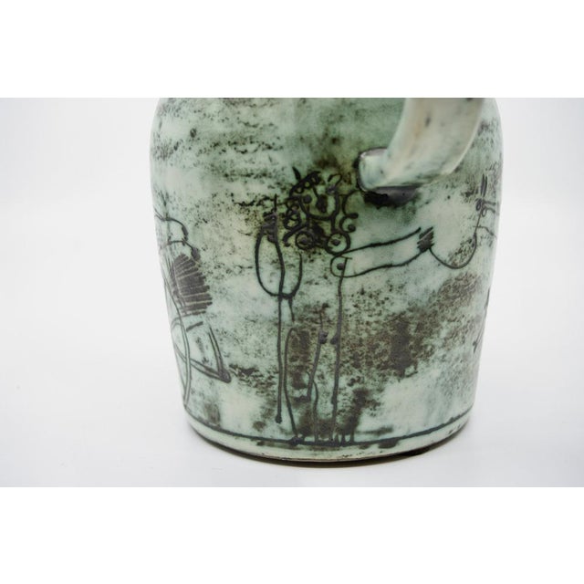 Large pitcher with a scarred decoration of fantastical giraffes harnessed to a cart guided by strange figures; smoke-...