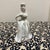 This elegant vintage porcelain figurine depicts a woman in a graceful pose. She is dressed in a long white gown with a and...