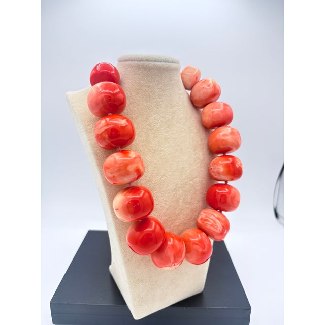 Signed (c) Kenneth Lane faux‑coral statement necklace featuring large polished resin beads in a vivid coral‑orange hue....