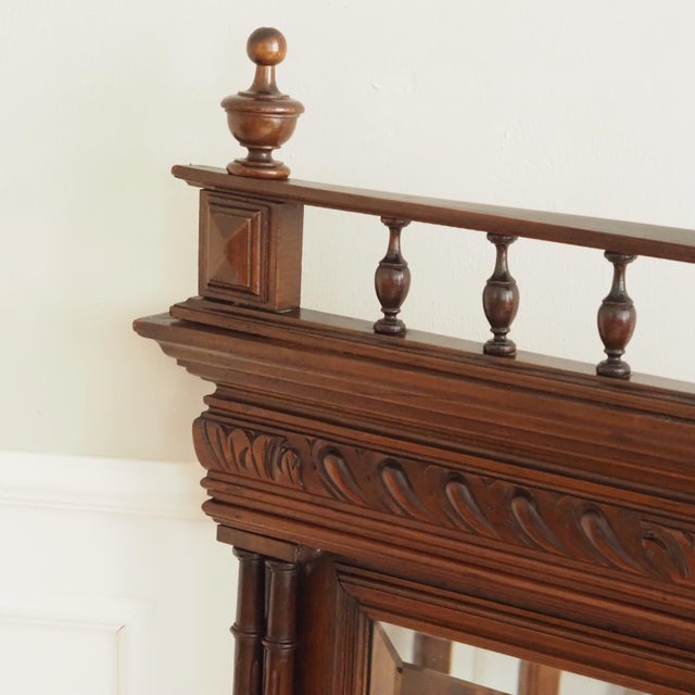 A wall mirror in the Neo-Renaissance style, crafted around 1880–1900 from dark-stained walnut. The design appears clearly...