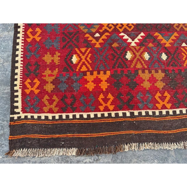 Add a touch of bohemian charm to your space with this handwoven wool Vintage kilim, featuring a vibrant geometric design....