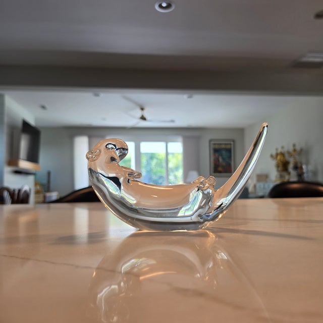 A signed Steuben crystal sea otter sculpture designed by James Archibald Houston, featuring the recognizable reclining...