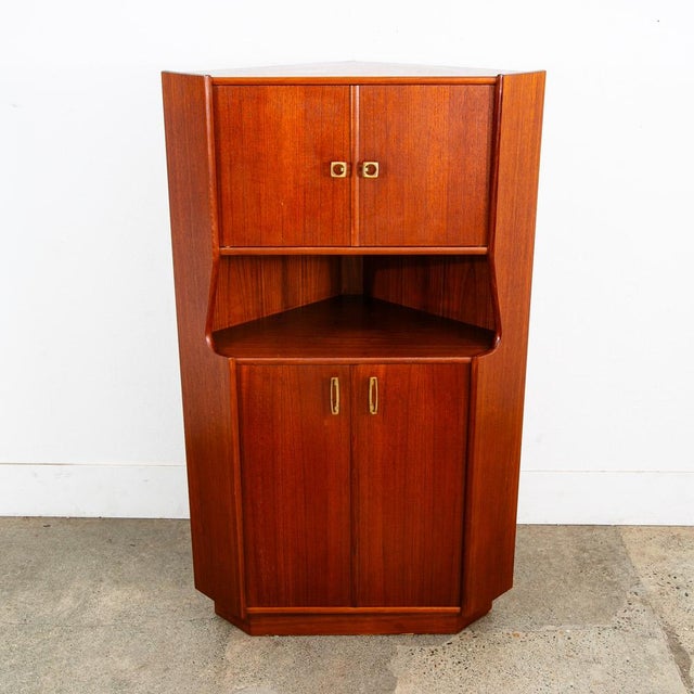 Outstanding Danish modern corner unit in teak. Comes with cabinet storage above and storage below. the center section...