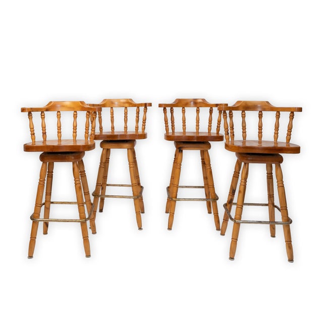 A charming set of four solid knotty pine swivel bar stools, crafted in a classic captain’s chair style, circa 1980. Each...