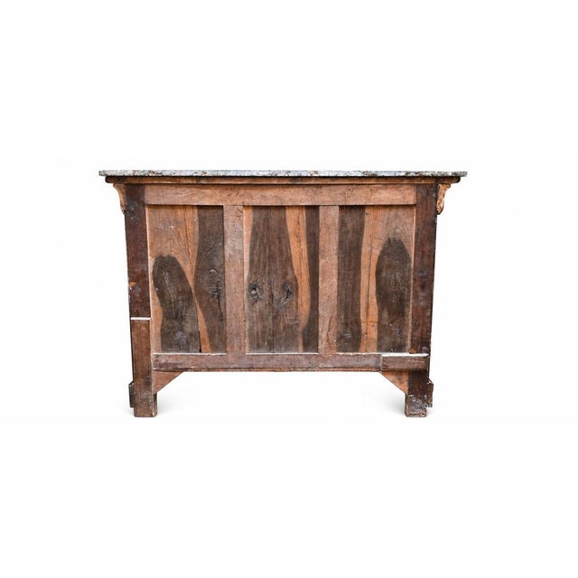 A Louis-Philippe commode in burr walnut veneer, surmounted by a Gris Saint-Anne marble top. It features four drawers, one...