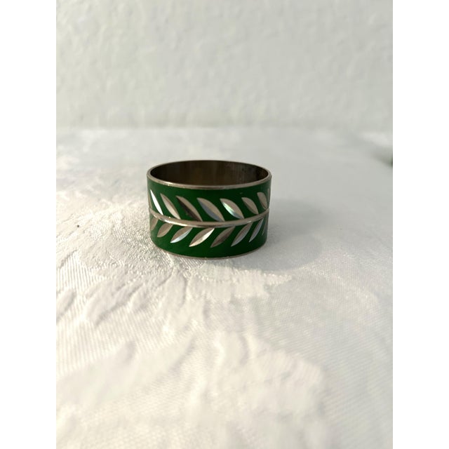 Lovely set of eight napkin rings in green enamel overlay with a lazer cut silver Laurel leaf design around perimeter....