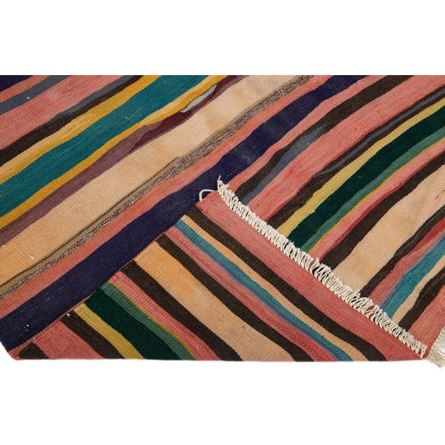 Beautiful vintage Turkish Kilim hand-knotted wool rug with a navy blue field. This piece has multicolor accents in an all-...