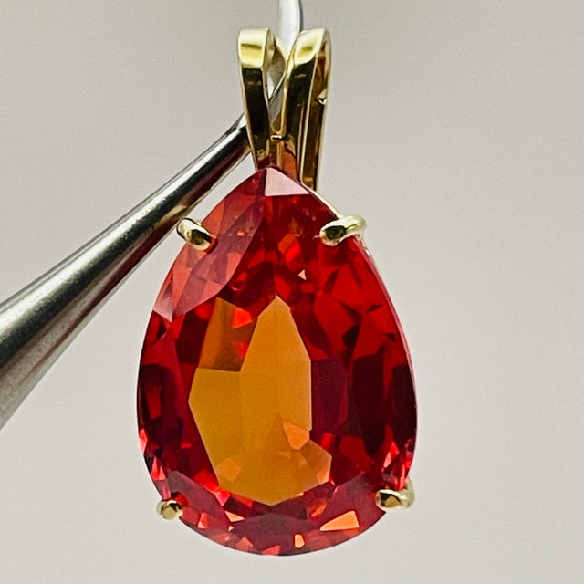 Breath taking signed Clyde Duneier 13-Carat Padparadscha Sapphire Pear Pendant in solid gold c. 1980. The gemstone...