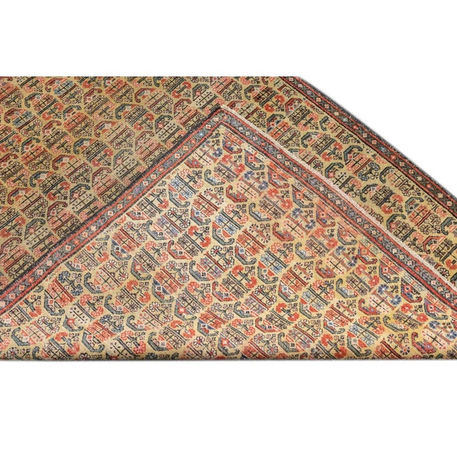 This west Persian Farahan village scatter shows a sandy straw field with closely set reversing rows of floriated botehs in...