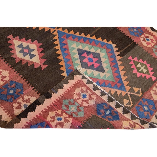 Beautiful vintage Turkish Kilim hand-knotted wool rug with a pink field. This piece has a red frame and multicolor accents...