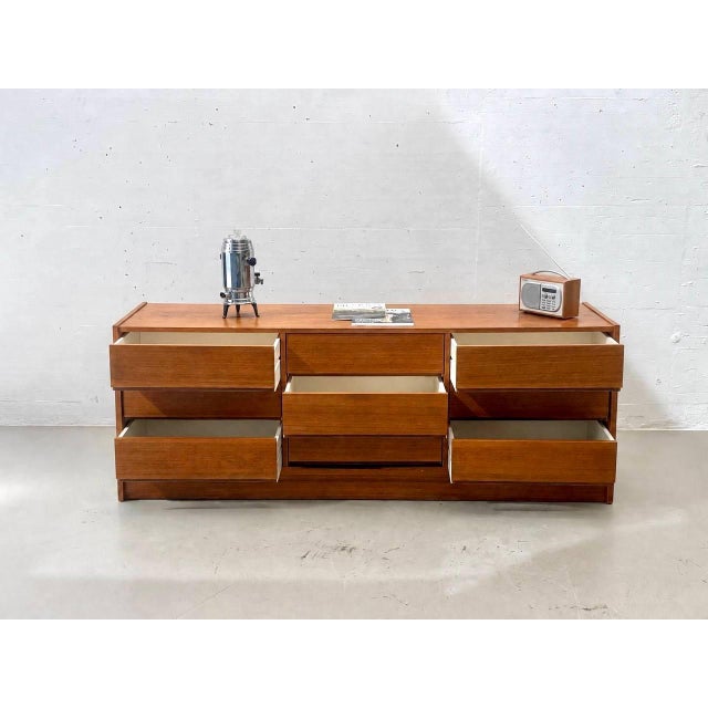 Large danish mid-century teak chest of drawers from the 1960s. Its exceptionally long, low silhouette and clean lines...