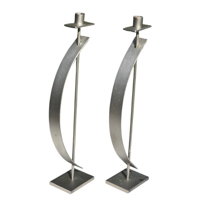 A striking pair of handcrafted sculptural steel candleholders by Rick Martin, each signed and dated 2003 on the underside....