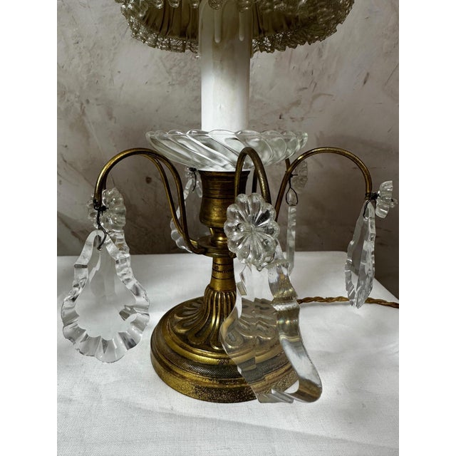 An elegant pair of lamps dating from the early 20th century, circa 1900, combining patinated brass, glass elements, and...