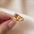 Elevate your style with this elegantly crafted bypass ring featuring a vibrant marquise-cut gemstone set in a modern gold...