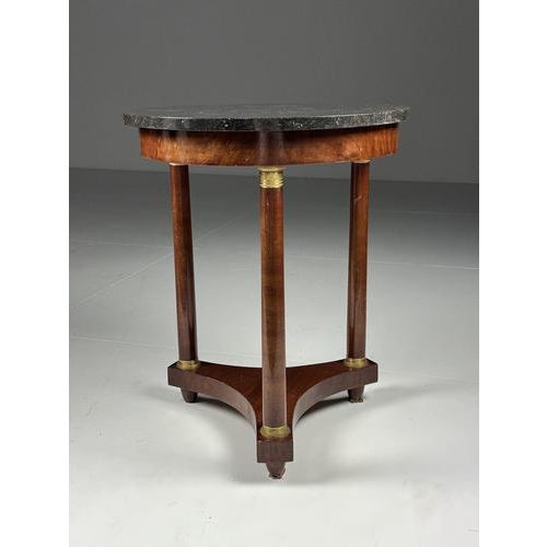Empire-style Gueridon side table. with a hardstone top. Mahogany veneer with bronze elements. Originally from France....