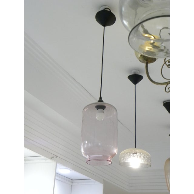 Elegant vintage blown glass pendant light with a simple, timeless design. The transparent, subtly pink-tinted glass shade...