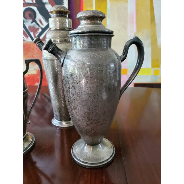 A nice set of three vintage mid century modern original cocktail shakers. Each maintains their original lids and screw in...
