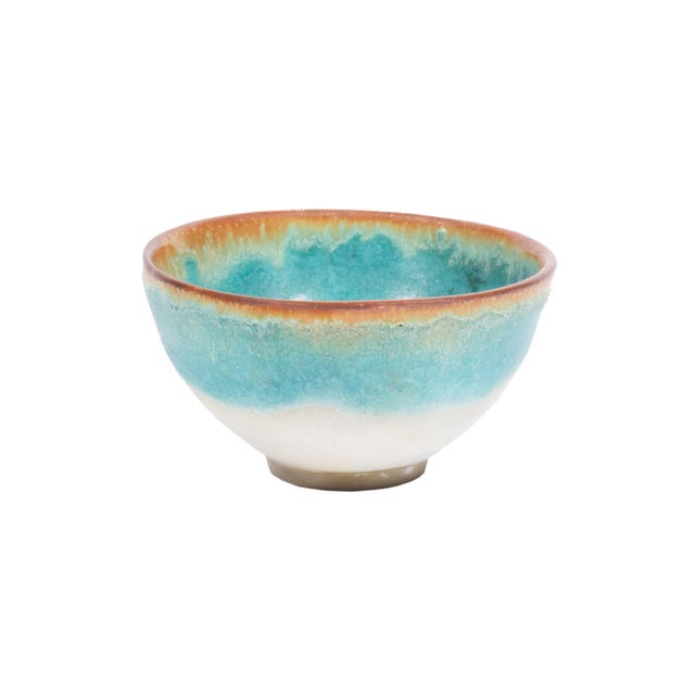 A studio pottery bowl by the American artist Abraham Cohn (born 1925). This bowl has a brown rim with light blue sides...