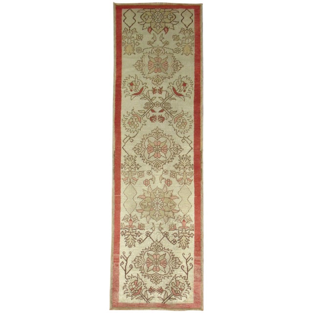 Narrow and short vintage Turkish Anatolian runner with accents in pinky rose, ivory and brown, circa 1940. Size: 2'2” x 7'6”.