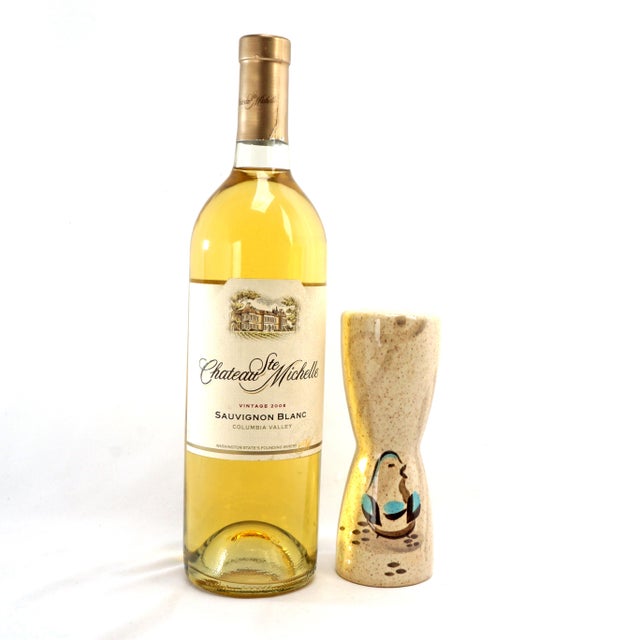 A large, decorative ceramic saltshaker by Redwing Pottery in the shape of an hourglass with a hand painted in a design of...