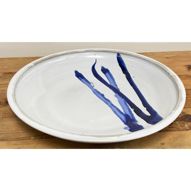 Wonderfully oversized vintage 17"dia studio pottery shallow bowl in speckled gray with vibrant blue brush stroke detail....