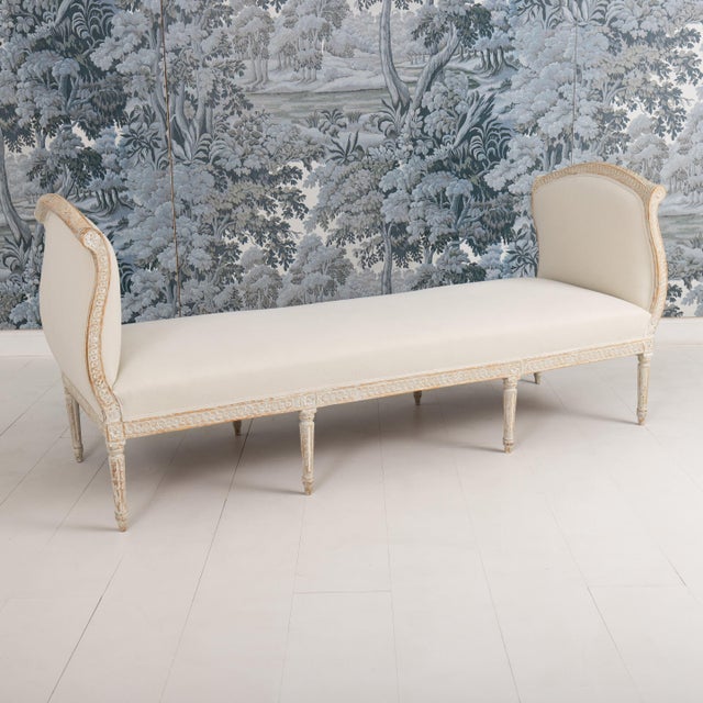 An elegant Gustavian period daybed from the 19th century wearing original paint and newly upholstered in linen. This piece...