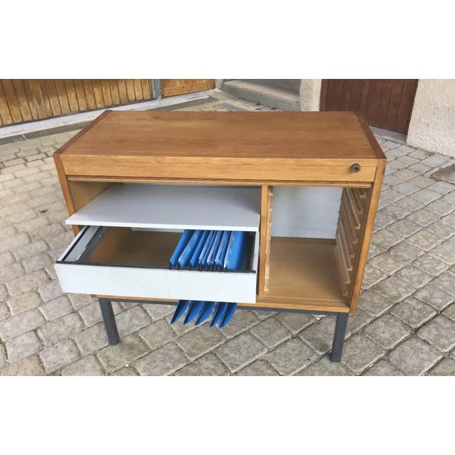 Small office furniture in oak veneer opened by a door sliding from bottom to top, the right shelves are missing on the...