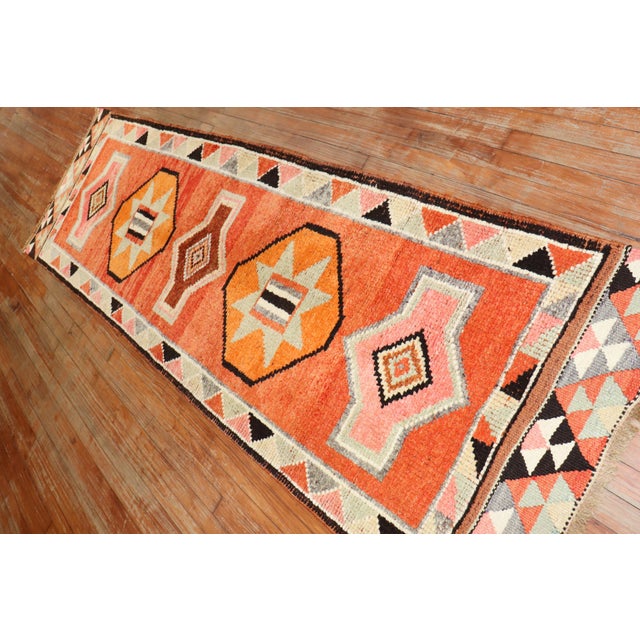 Mid 20th century tribal Turkish Anatolian runner with a tribal design in brown, orange, pink, and ivory dominant accents...