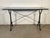 This vintage French iron and dark marble desk table, dating to the 1960s, features a striking pedestal base and a refined,...