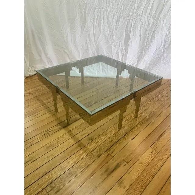 Attributed to Brueton stainless steel cocktail table has modern angular lines with a complimentary glass table top....
