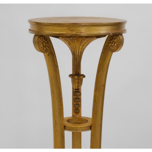 Antique giltwood torchere with circular top, raised on three swept supports with central swag drop, and terminating on paw...