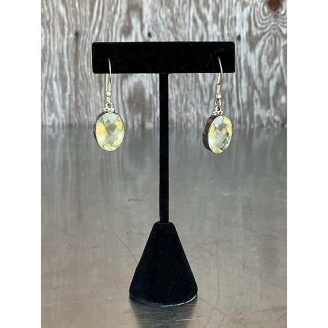 These vintage drop earrings are compact, elegant ovals that hang from classic French wire hooks, each with a neat coiled...