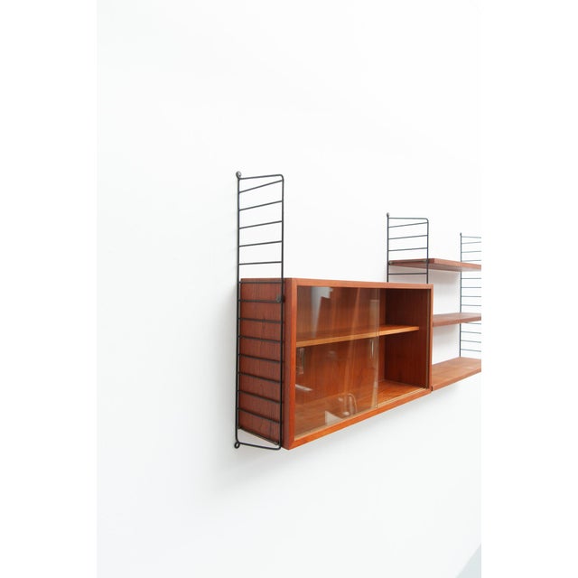 Wall shelf with a teak wood cabinet featuring sliding glass doors. Design: Kajsa & Nils Nisse Strinning 3 shelves, 78 cm x...