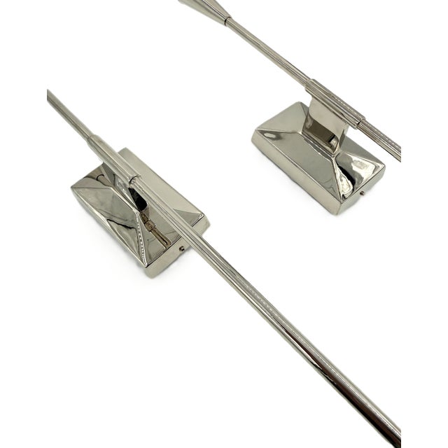Featuring a sleek polished nickel finish, elongated architectural silhouette, and frosted acrylic shades, these sconces...