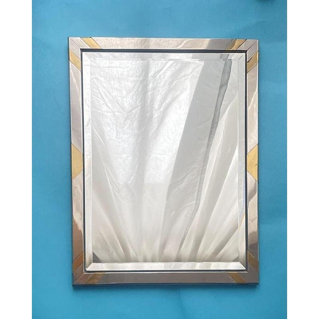 A striking modernist wall mirror dating to the 1970s, featuring a sculptural mixed-metal frame in polished steel accented...