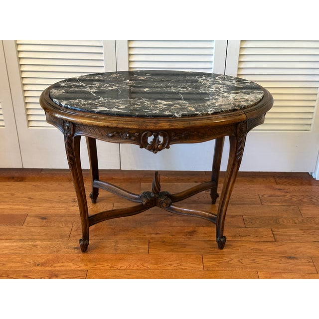Exceptional Louis XV style center table with a oval Portoro marble top. Crafted of carved in a raised foliate motif. The...