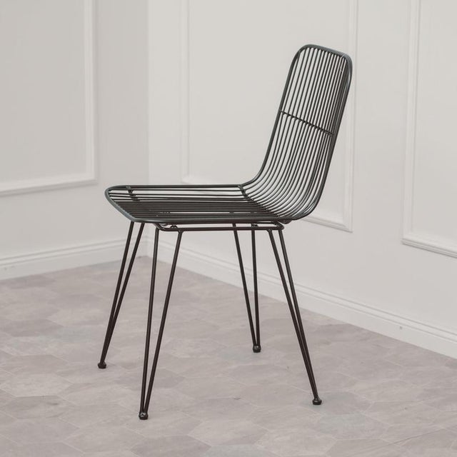 A contemporary chair in powder-coated metal, crafted in an industrial style as an open wire frame with a minimalist...