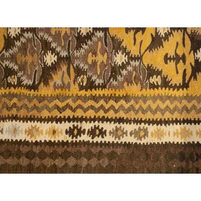 An early 20th century Persian Qazvin Kilim runner with an all-over diamond floral pattern surrounded by multiple...