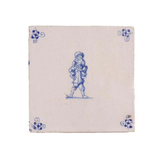 Two Delft faience tiles featuring illustrations of double figures and spider corner decorations in cobalt underglaze blue....