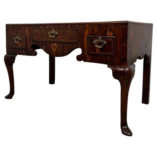 A handsome 18th-century English low side table in the Queen Anne style, finely crafted from walnut and distinguished by...
