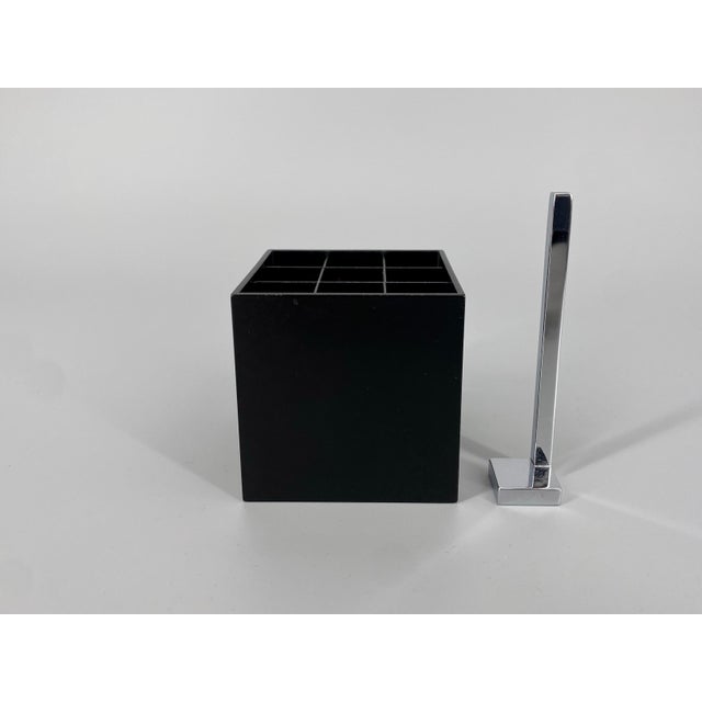 Ashtray/pen holder * Made of metal * Color: black * with a chrome-plated cigarette extinguisher * Constructed from a cube-...