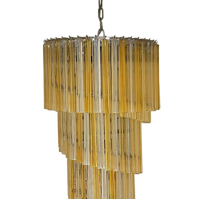 An elegant Italian spiral chandelier composed of alternating amber and clear Venini glass prisms, suspended in cascading...